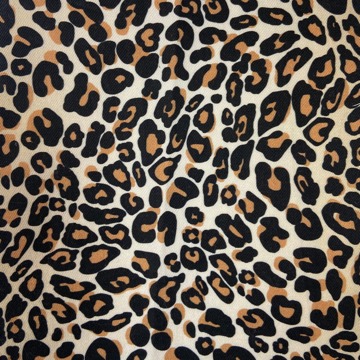 Sergé de coton imprimé motif léopard fausse fourrure tachetée motif tâches noir et marron sur fond beige guépard animal impression