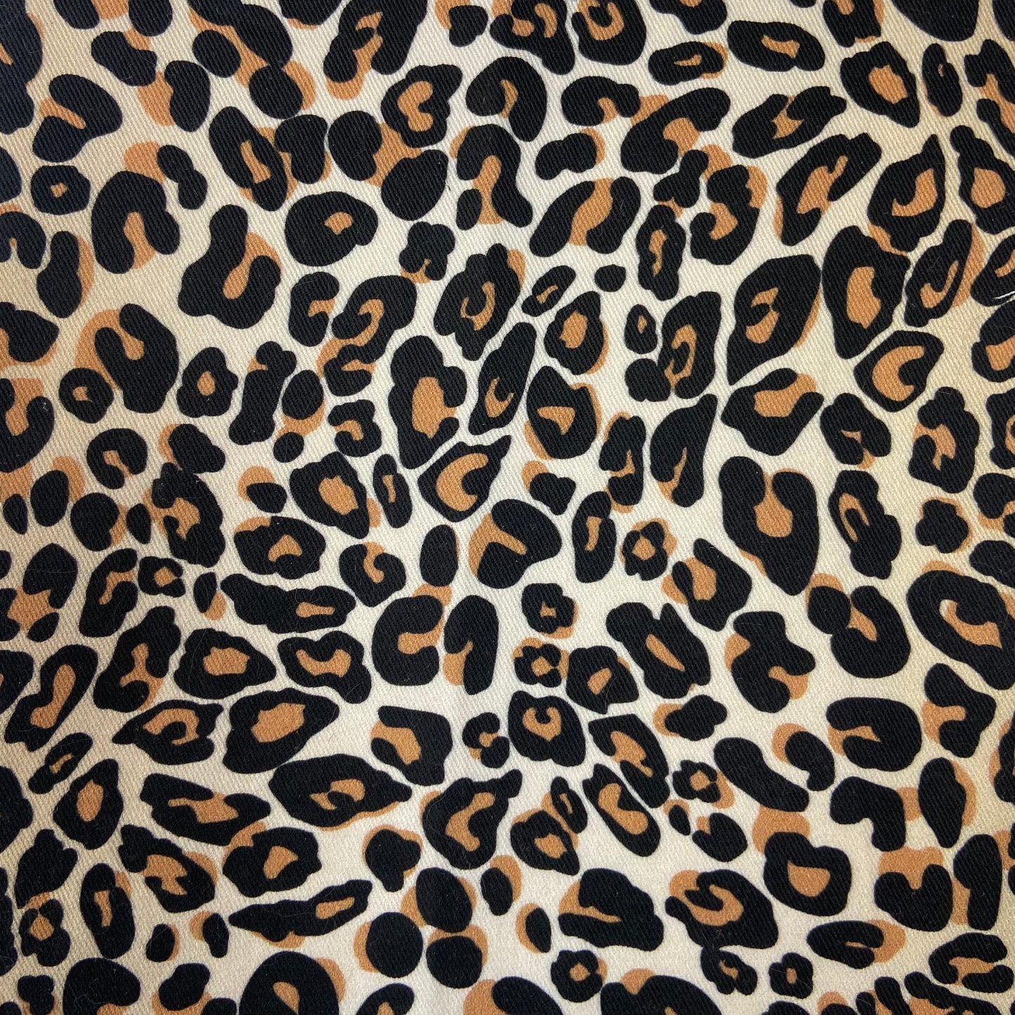 Sergé de coton imprimé motif léopard fausse fourrure tachetée motif tâches noir et marron sur fond beige guépard animal impression 